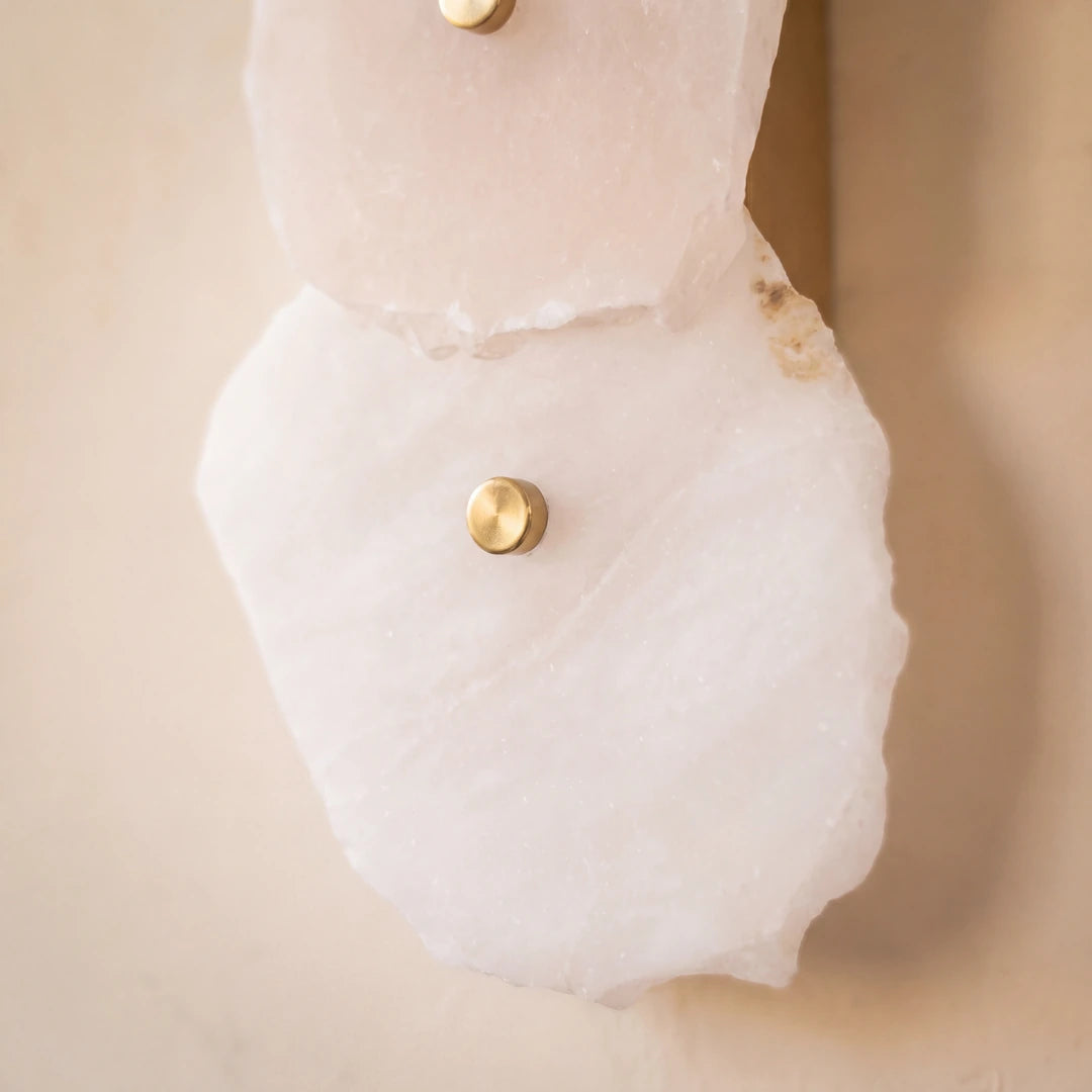 Close-up of a white garment with gold buttons on a beige background